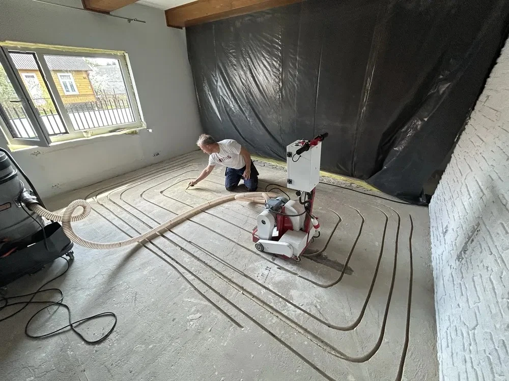 Specialist floor milling machine cutting channels for underfloor heating with dust extraction connected